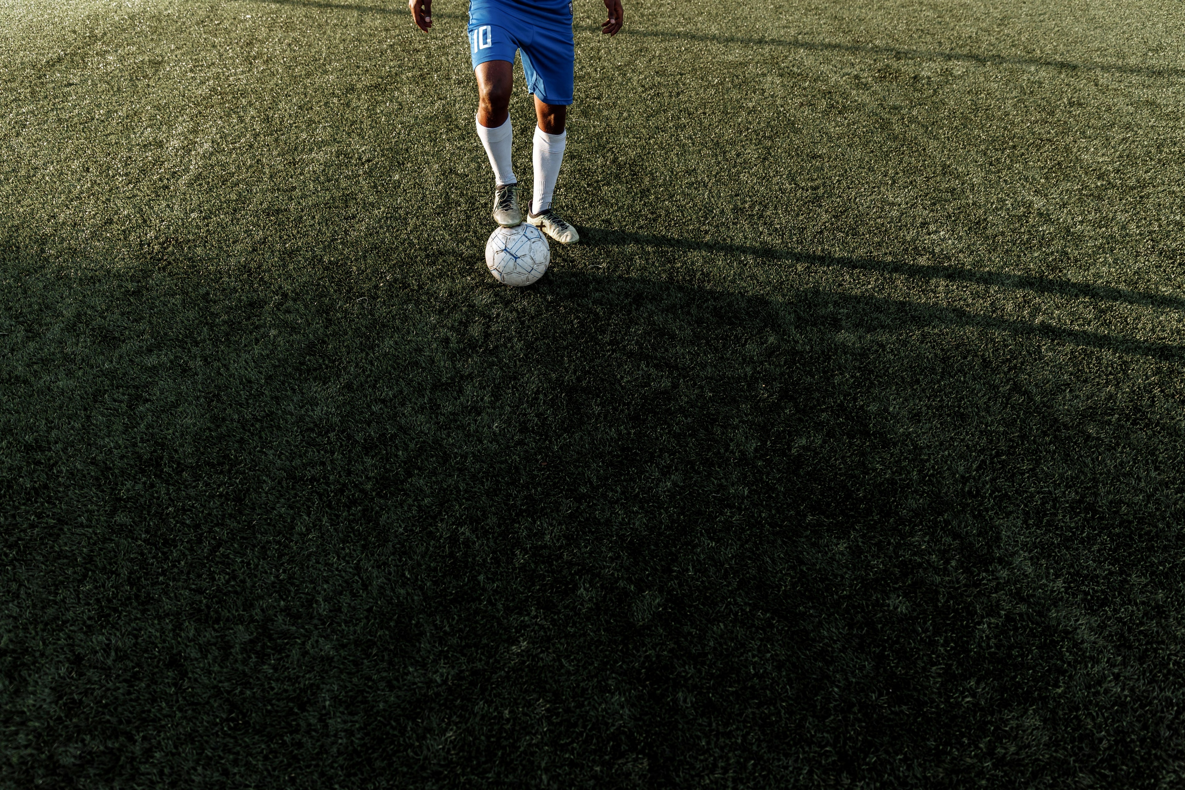 Jogador de futebol com bola no campo